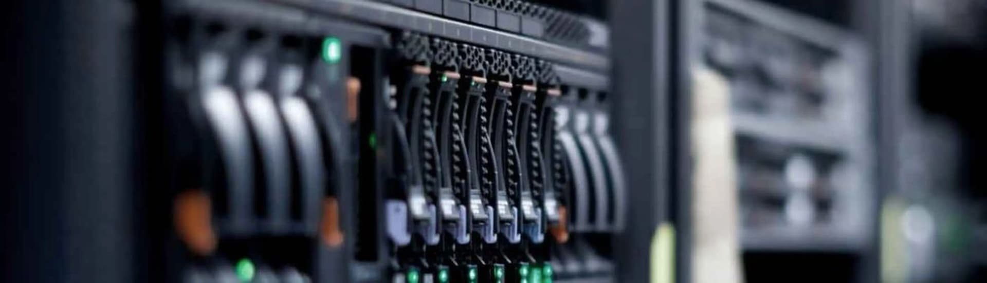 Close-up of hot-swap drive bays in a server rack, with green activity lights