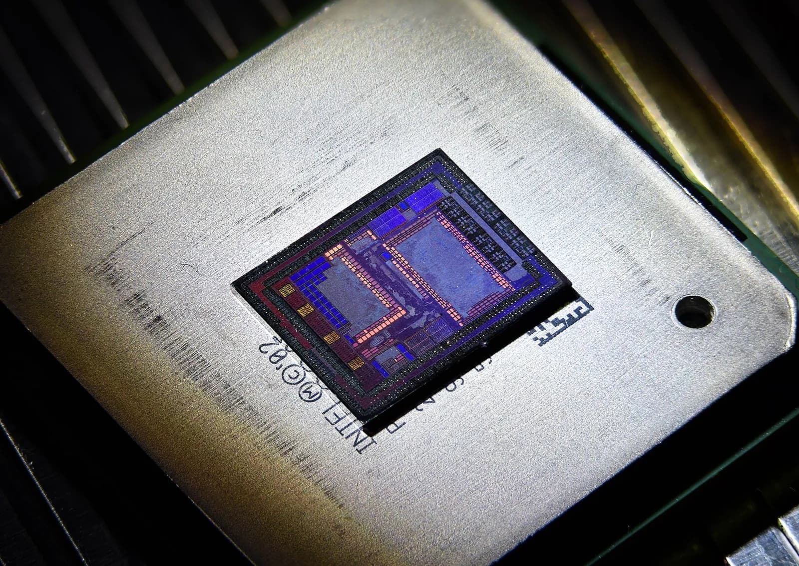 Macro shot of a network switch chip with the die exposed, glowing blue and violet