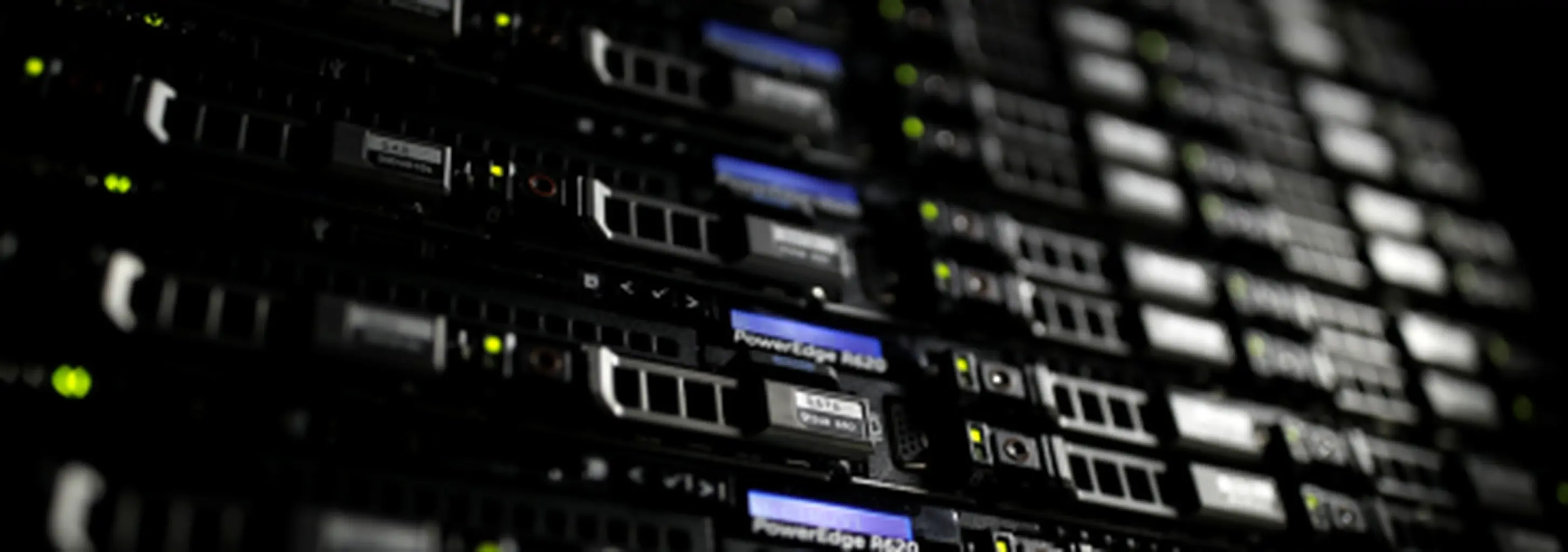 Stacked rack servers in the dark, front panels glowing with status lights